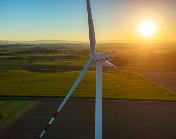 Beautiful sunset above the windmills on the field