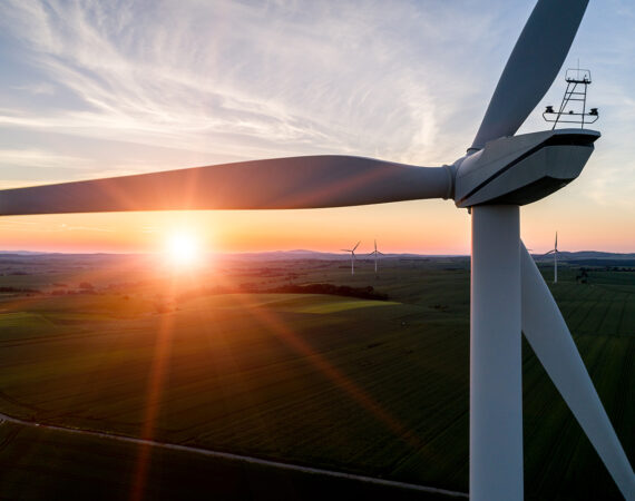 Aerial view on the sunset above the windmill on the field